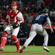 Mariners’ Sam Haggerty runs by Angels ‘catcher Max Stassi and heads for home plate in the ninth inning against the Angels.